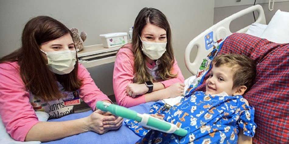 Staff shows young patient how to use new iPad